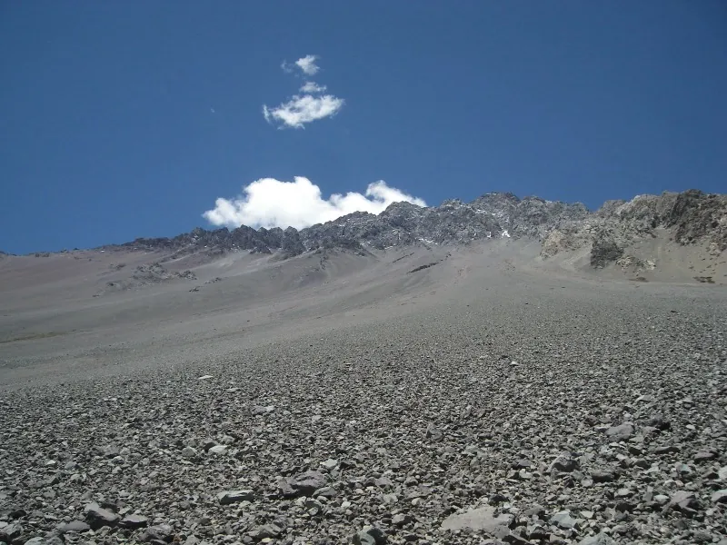 Vista panorámica del Embalse El Yeso rodeado de montañas andinas nevadas