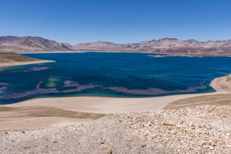 Laguna del Maule en verano con aguas turquesas y montañas volcánicas en la Región del Maule