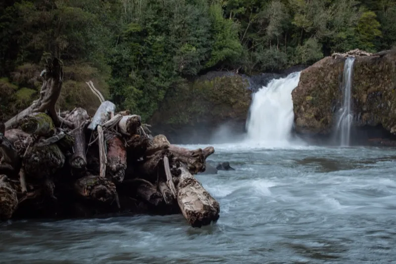 Vista panorámica del Salto del Indio con caudal abundante entre rocas y vegetación en Anticura