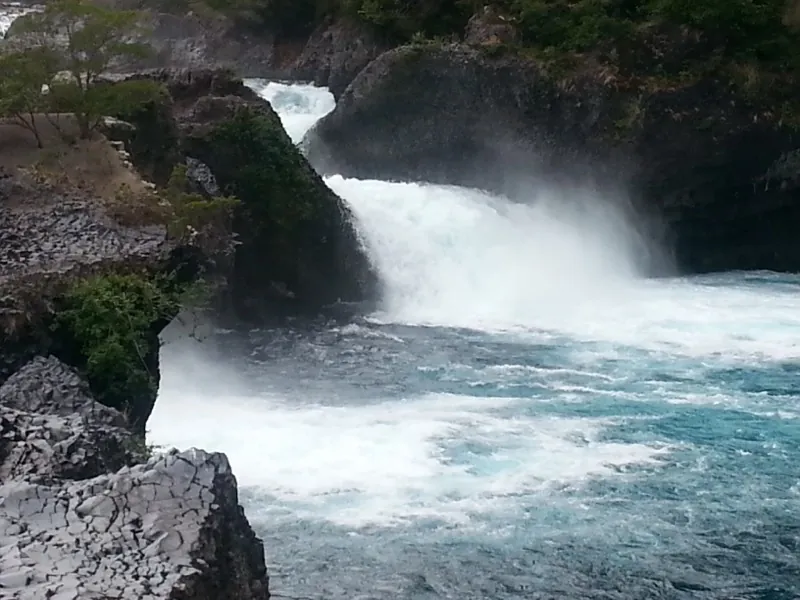 Detalle del agua turquesa cayendo sobre la roca basáltica en los Saltos del Petrohué